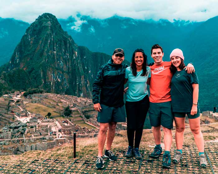 Tourists posing for a photo with Machu Picchu's background.